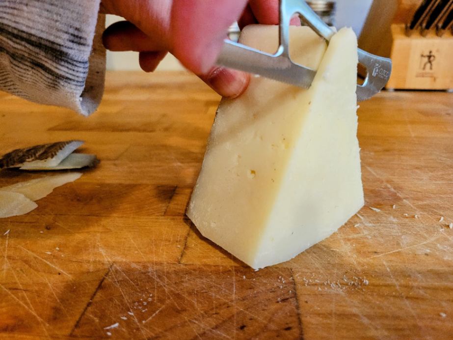 Cutting Manchego cheese with a cheese knife