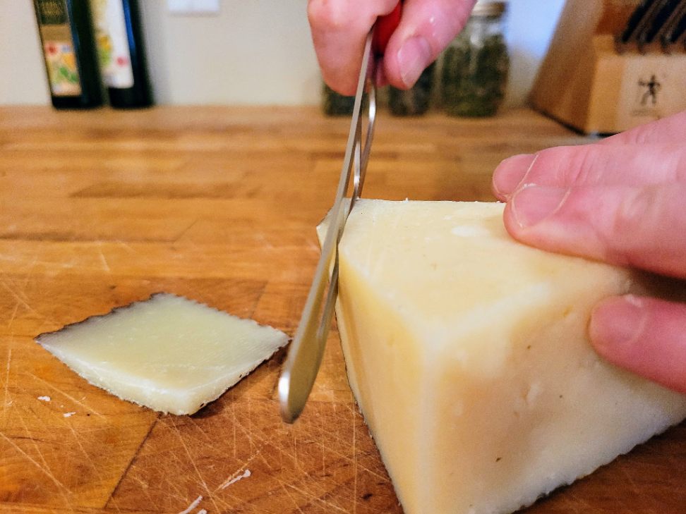Cutting rind off Manchego cheese