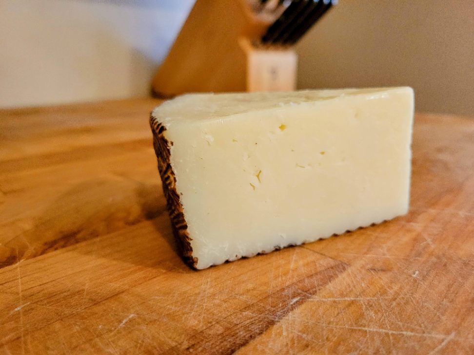Manchego cheese block on butcher block
